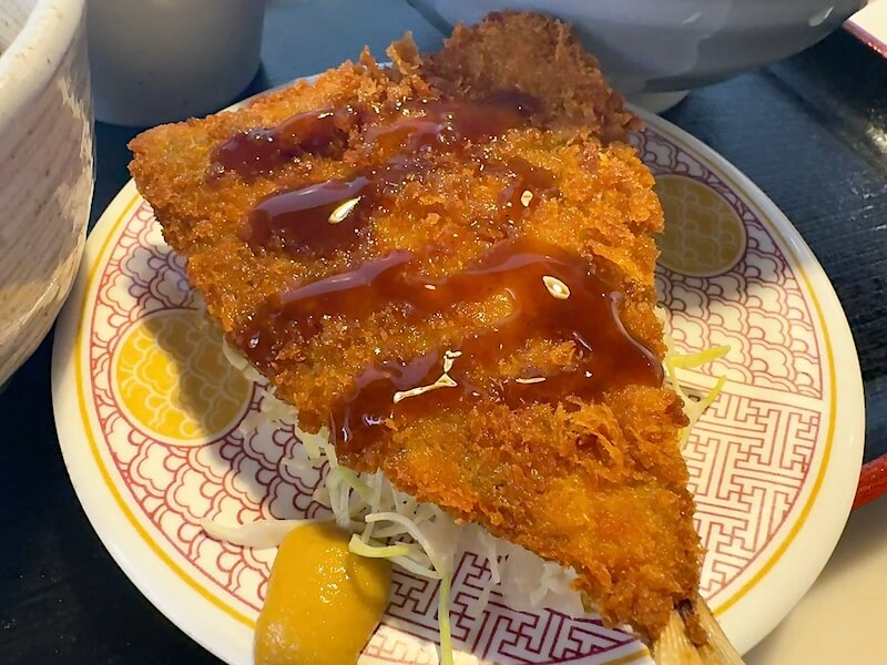 アジフライの下にキャベツの千切りがあります。