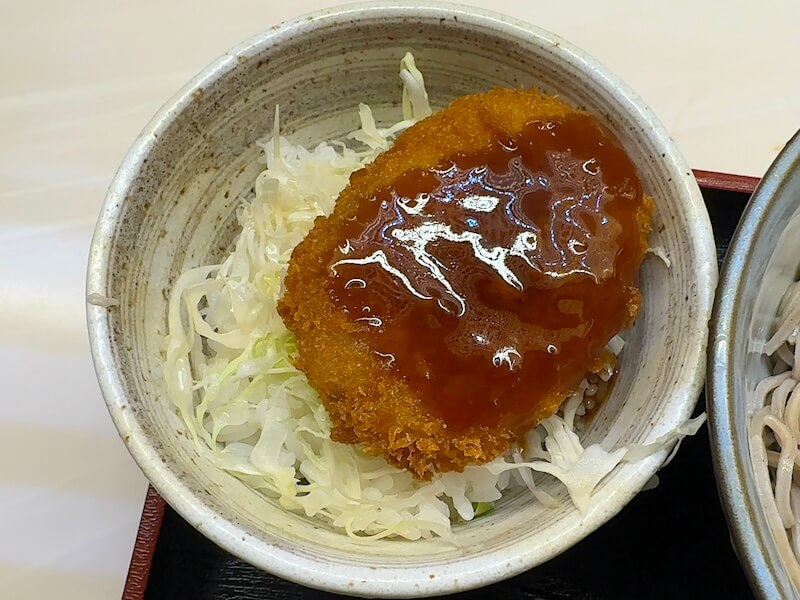 ご飯の上にキャベツとコロッケがのってます。